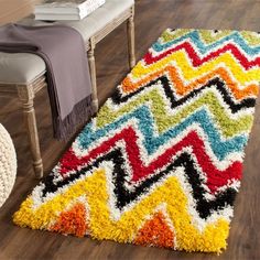 a multicolored rug on the floor next to a chair