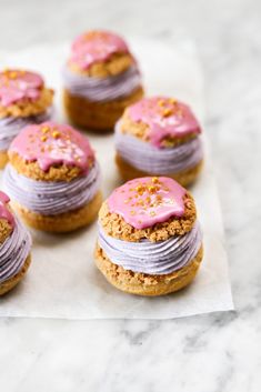 there are many cookies with pink frosting on top of each other and sprinkled with icing