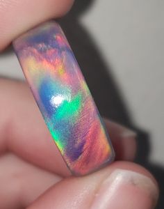 OPAREX synthetic opal is more durable and cost effective than your average opal, ensuring you will have your ring for years to come! The color shifts depending on the angle it is viewed, creating a rainbow of colors. The material is semi transparent, giving it an almost glowing effect. It is inspired by Dragon's Fire, displaying all the colors of a flame at it's hottest point. 8 mm wide This synthetic opal ring comes in a size 8 1/2 and was turned on a lathe. It is then sanded from 60 grit all t Iridescent Opal Ring With Unique Style, Unique Iridescent Round Opal Ring, Multicolor Opal Round Ring, Multicolor Opal Ring Gift, Unique Handmade Iridescent Opal Ring, Handmade Iridescent Opal Ring, Iridescent Opal Ring As A Gift, Iridescent Opal Ring Gift, Iridescent Opal Ring Perfect For Gifts