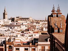 the city is full of tall buildings and towers with spires on top, in front of a clear blue sky