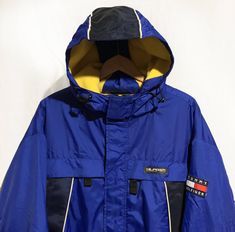 "Vintage 90's Tommy Hilfiger Athletic Gear Fleece Lined Winter Jacket Flag Logo Spell Out Color Block Navy /Blue/Yellow Size M Condition: Very Good Yellow /Blue/White Color Block Tommy Hilfiger Classic Flag Logo Patch Embroidered on Left Arm Heavy Duty Zipper Close Pockets on Front of Jacket Fleece Lining Inside of Jacket - Adjustable Strap Wrist Cuffs Measurements Pit-to-Pit: 24\"/64cm Top-to-Bottom: 28\"/71cm pit to cuff: 21\"/54cm Please keep in mind that colours from the pictures may vary be Retro Yellow Windbreaker For Winter, Vintage Yellow Windbreaker For Winter, 90s Yellow Streetwear Outerwear, 90s Yellow Outerwear For Streetwear, 90s Style Yellow Winter Outerwear, 90s Yellow Winter Outerwear, Yellow Long Sleeve Outerwear With Fleece Lining, 90s Yellow Windbreaker For Winter, Yellow 90s Windbreaker For Winter