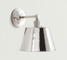 a chrome wall light on a white wall with a black and white stripe down the side