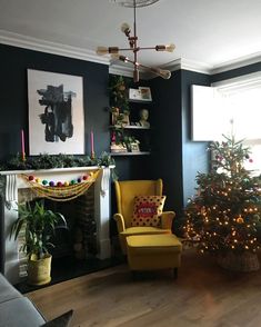 a living room filled with furniture and a christmas tree in front of a fire place