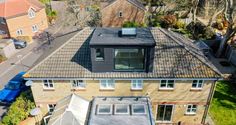 an aerial view of a house with tiled roof and glass windows on the top floor