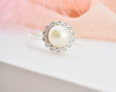 * Stunning handmade solid gold pearl ring. Adorned with tiny beads of white zircon gemstone to emphasize the unique design. This ring is designed to look elegant from all sides of your finger. You will not be able to take your eyes off the fascinating color of opal stone and the magnificent glitter of solid gold. 14K and 18K options are avaliable. It is suitable for daily use * ★Item Details ♥Made to Order ♥Gold Kt: 14K & 18K ♥Available Gold Color: Gold, Rose Gold, White Gold ♥Pearl Stone Si White Pearl Ring With Halo Setting As Gift, Diamond Pearl Ring With Halo For Gift, White Pearl Ring With Halo Design Gift, White Gold Pearl Ring With Halo Setting As Gift, Round Diamond Ring With Pearl Drop For Gift, Anniversary Pearl Ring With Halo Setting And Cubic Zirconia, Anniversary Pearl Ring With Halo Setting, Diamond Rings With Pearl Drop Gift, Dainty Opal Necklace