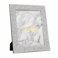 a white and gold frame with sparkles on the edges that says sparkle in front of it