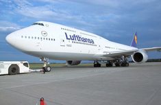 a large jetliner sitting on top of an airport tarmac next to a truck