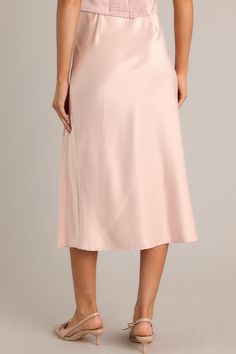 Unleash your inner glam with the Park Avenue Glam Blush Pink Satin Midi Skirt. This statement piece will elevate your wardrobe with its silky, smooth satin fabric and figure-flattering midi length. Perfect for both casual and formal occasions, this skirt will have you feeling confident and stylish all day long. Dress up or dress down, the choice is yours! This blush pink skirt features a high waisted design, an elastic waistband, a slit up the leg, and a satin material.  95% Polyester & 5% Spandex  Unlined  Hand Wash Cold Manufactured in China Designed in The USA  Model is wearing a size small Blush Pink Skirt, Sorority Rush Dresses, Rush Dresses, Feeling Confident, Satin Midi Skirt, Dress Bra, Long Crop Top, Park Avenue, Little White Dresses