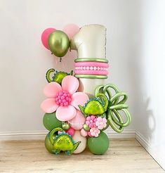 there are balloons and flowers on the floor next to each other in front of a white wall