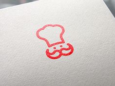 a chef's hat on top of a white piece of paper with red ink