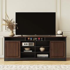 a large flat screen tv sitting on top of a wooden entertainment center cabinet in a living room