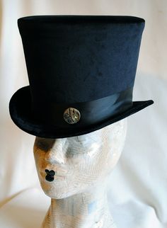 The Baron is a simple and yet elegant victorian inspired top hat.This gothic hat is covered with soft black velvet.It is elegantly embellished with black ribbon around the crown, as well as a beautiful vintage watch movement. Available in black (pictured) or ivory with matching ribbon. Need this TOP HAT in another color? with more decoration? Just send me a message to talk about a custom hat made just for you! This hat is fully lined with satin and it is made to according to your exact head meas Victorian High Crown Costume Hat, Steampunk Brimmed Top Hat For Costume, Steampunk Fitted Brimmed Top Hat, Steampunk Top Hat With Short Brim For Costume, Steampunk Fitted Costume Hat With Short Brim, Victorian Costume Hat With Curved Brim, Steampunk Fitted Top Hat For Costume, Victorian Fitted Brimmed Costume Hats, Victorian Adjustable Cloche Hat