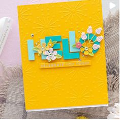 a close up of a greeting card with flowers on it and the word hello written in large letters