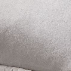 a close up view of a bed with white sheets