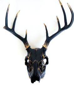 an animal's skull with gold antlers is shown against a white background,