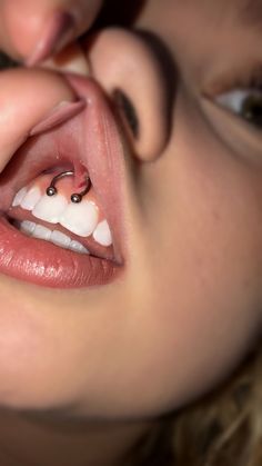 a close up of a woman's mouth with an object in the middle of her nose