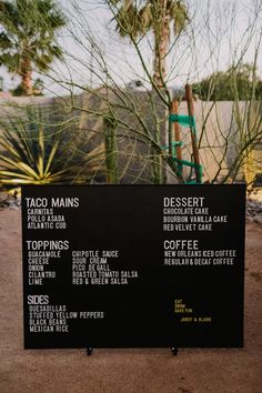 the menu for taco mains is displayed in front of a cactus tree and fence