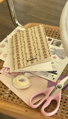 the table is cluttered with papers, scissors and other crafting supplies on it