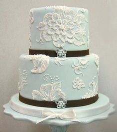 a three tiered wedding cake with white and brown decorations