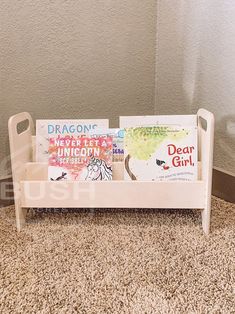 two children's books are sitting on a toy bench in front of a wall