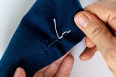 someone is stitching the side of a piece of fabric with their hands on it