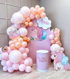 a pink unicorn themed birthday party with balloons and decorations