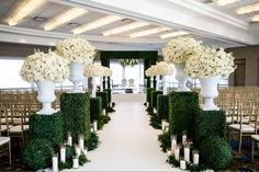 the ceremony room is decorated with white flowers and greenery