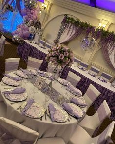 the tables are set with purple and white decor