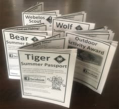 several flyers sitting on top of a wooden table