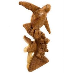 a carved wooden bird sitting on top of a tree branch with two smaller birds perched on it's back