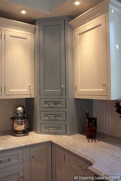 a kitchen with white cabinets and marble counter tops in the center is lit by recessed lights