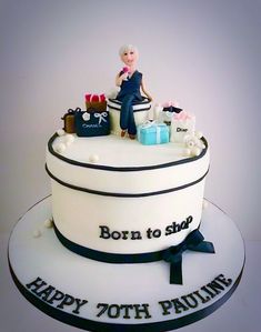 a birthday cake with a woman sitting on top of it and presents in the background