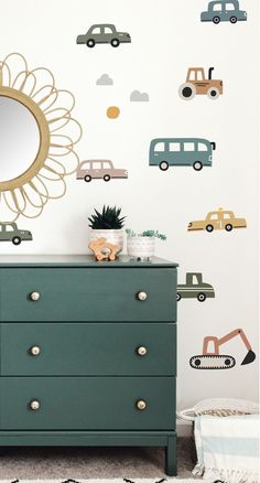 a green dresser sitting next to a wall with cars on it