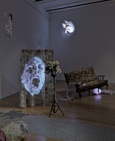 an image of a person's face projected on the wall next to a couch