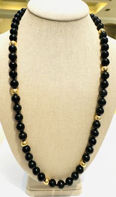 Enchanting vintage 1970s beaded necklace! This elegant necklace features 10mm, natural, hand tied, onyx beads, accented by eight 7.7mm, solid 14k yellow gold beads. The necklace is substantial, weighing 78 grams! It is 27 inches long. This gorgeous necklace is in excellent condition! Classic Onyx Beaded Necklace With Black Beads, Formal Onyx Beaded Necklaces With Polished Beads, Formal Onyx Beaded Necklace With Round Beads, Formal Onyx Beaded Necklace With Polished Beads, Onyx Bead Necklaces With 8mm Round Beads, Onyx Bead Necklace With 8mm Round Beads, Formal Onyx Beaded Necklace, Formal Onyx Beaded Necklaces, Formal Black Jewelry With Large Beads