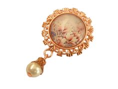 This small brooch is a beautiful accessory for many occasions: as a lapel ornament, on cases and small bags, on jackets and jackets, as a scarf brooch and much more. The brooch is made of rose gold colored metal and a handcrafted glass cabochon featuring a magnolia motif. A pendant with a glass wax bead is attached to the bottom of the brooch. The brooch, including the pearl pendant, measures 4.8 L x 3 W cm. Elegant Pink Enamel Pin, Elegant Pink Enamel Brooch Pin, Elegant Pink Enamel Pin For Gift, Elegant Rose Gold Flower Brooches, Rose Gold Brooch Pins For Gifts, Elegant Handmade Pink Brooches, Rose Gold Flower Brooches As Gift, Formal Rose Gold Flower Brooches, Elegant Rose Gold Lapel Pin Brooch