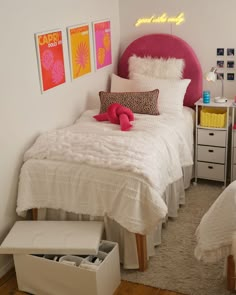 a white bed sitting next to a pink headboard