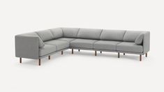 a gray sectional sofa with wooden legs and arms on an isolated white background, viewed from the front