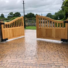 two wooden gates open on a brick walkway