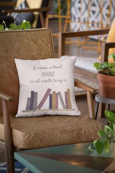 a brown chair with a pillow on top of it next to a potted plant