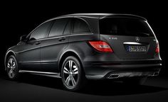 the back end of a black mercedes c - class estate car in a dark room