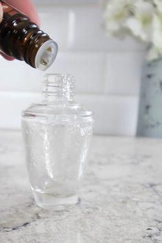 a person is pouring some liquid into a glass bottle on a marble counter top with flowers in the background