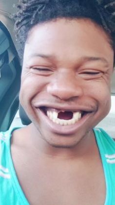 a woman with dreadlocks smiling in the back seat of a car