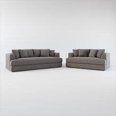 two gray couches sitting next to each other on a white floor with no one in it