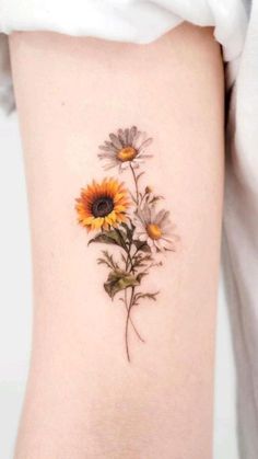 a sunflower tattoo on the right side of the thigh, with leaves and flowers growing out of it