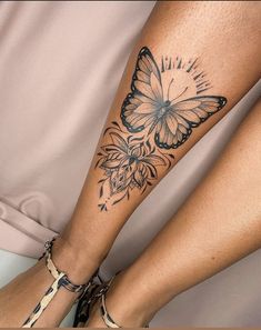 a woman's leg with a butterfly tattoo on it