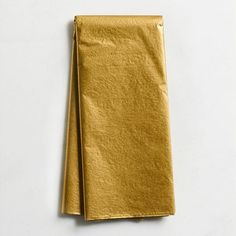 a gold colored napkin on a white surface