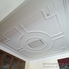 the ceiling is painted white and has an intricate design on it's center piece