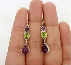 A majestic Amethyst earring with glittering Peridot gemstone set beautifully in simple sterling silver earring will make these an instant favourite. Jewelry that can add glamour to your outfits. Precious gems for your precious one. Gemstone:- Amethyst, Peridot Gemstone Shape:- Pear,Round Gemstone Size:- 7 mm x 10 mm Pear(Amethyst), 6 mm x 8 mm Pear(Peridot), 4 mm x 4 mm Round(Amethyst) Material:- Solid 925 Sterling Silver Main Stone Creation:- Natural Dimension:- 8 mm Wide x 42 mm Long with hook                                                      ❏ BENIFITS OF SILVER > Healing Properties > Protects From Bacteria > Hypoallergenic > Pain Relief ❏ BENIFITS OF AMETHYST > Natural Tranquilizer > Fights Addictions > Dissolves Negative Energy > Physical Healing > Psychic Abilities ❏ BENIFITS OF P Purple Sterling Silver Teardrop Dangle Earrings, Teardrop Multi-stone Amethyst Earrings, Purple Teardrop Multi-stone Jewelry, Sterling Silver Multi-stone Teardrop Earrings, Purple Multi-stone Teardrop Earrings, Purple Multi-stone Sterling Silver Earrings, Sterling Silver Multi-stone Drop Earrings, Amethyst And Peridot, Glamorous Jewelry