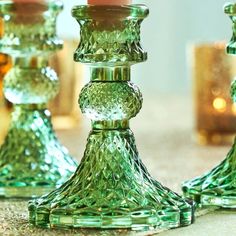 three green glass candlesticks sitting next to each other